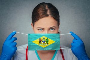 Coronavirus in U.S. State Delaware, Female Doctor Portrait, protect Face surgical medical mask with Delaware Flag. Illness, Virus Covid-19 in Delaware